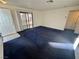 Living room with blue carpet, patio access, and kitchen bar at 5161 Lindell Rd # 107, Las Vegas, NV 89118