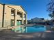 Community pool with surrounding buildings and patio furniture at 5161 Lindell Rd # 107, Las Vegas, NV 89118