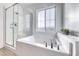 Bright bathroom featuring a bathtub and glass-enclosed shower with white subway tile and modern fixtures at 965 Nevada State Dr # 1101, Henderson, NV 89002