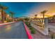 Inviting entrance to The Waverly community with lush landscaping and modern signage, bathed in sunset colors at 965 Nevada State Dr # 1101, Henderson, NV 89002