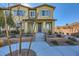 Tan townhome with gray shutters, landscaping, and walkway at 965 Nevada State Dr # 1101, Henderson, NV 89002