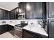 Modern kitchen featuring dark cabinetry, stainless steel appliances, and white countertops at 965 Nevada State Dr # 1101, Henderson, NV 89002