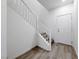 Clean, minimalist stairway featuring light wood-look floors and white railings, leading to upper level at 965 Nevada State Dr # 1101, Henderson, NV 89002