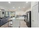 Living room and kitchen area with modern appliances and an island with barstool seating at 361 Andy Wheeler Dr, Henderson, NV 89011