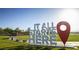 Community sign reading 'It All Starts Here' in a lush green area at 361 Andy Wheeler Dr, Henderson, NV 89011