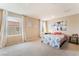 Neutral bedroom with carpet, an accent wall picture and two large windows at 5372 Silver Branch Ave, Las Vegas, NV 89118