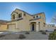 Two-story house with tan exterior, two-car garage, and desert landscaping at 6547 Velvet Silk St, North Las Vegas, NV 89084