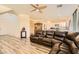 Living room with sectional sofa, wood-look floors, and kitchen view at 6547 Velvet Silk St, North Las Vegas, NV 89084