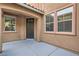 Home entrance with porch featuring a dark-colored front door and several windows at 6616 Sea Swallow St, North Las Vegas, NV 89084