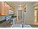 Updated kitchen with wood cabinets, granite counters and adjacent laundry area at 7151 S Durango Dr # 214, Las Vegas, NV 89113