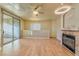 Open living room featuring a fireplace, wood floors, ceiling fan, and sliding glass doors to a balcony at 7151 S Durango Dr # 214, Las Vegas, NV 89113