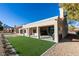 Back exterior view featuring well-manicured lawn, covered patio, and modern architectural design at 8713 Litchfield Ave, Las Vegas, NV 89134