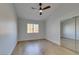 Bedroom with wood floors, a ceiling fan, a window, and a closet with sliding mirrored doors at 8713 Litchfield Ave, Las Vegas, NV 89134