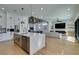 Open-concept living room and kitchen, featuring a fireplace and modern lighting fixtures at 8713 Litchfield Ave, Las Vegas, NV 89134