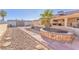 Landscaped backyard with brick pathway, fire pit, and rock features at 1550 Desertaire Way, Las Vegas, NV 89110