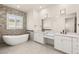 Bathroom features soaking tub, stone accent wall, dual sinks, and granite countertops at 1725 Bannie Ave, Las Vegas, NV 89102