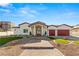 A home exterior with a well-manicured lawn, a paved driveway, and a landscaped entrance, enhancing its curb appeal at 1725 Bannie Ave, Las Vegas, NV 89102