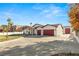 Exterior featuring a spacious driveway, well-maintained landscaping, and red garage doors for added curb appeal at 1725 Bannie Ave, Las Vegas, NV 89102