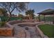 Landscaped backyard with terraced patio and fire pit at 2205 Alia Ct, Las Vegas, NV 89102