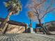 Tan house with a large garage door and palm trees at 2205 Alia Ct, Las Vegas, NV 89102