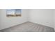 Bedroom with neutral carpet, bright white walls, and a window offering views of the neighborhood at 633 N Water St, Henderson, NV 89015