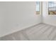 Bright bedroom featuring neutral carpeting, white walls, and neighborhood views from two windows at 633 N Water St, Henderson, NV 89015