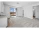 Bright living area featuring a sliding glass door to balcony, modern finishes, and an adjacent wet bar at 633 N Water St, Henderson, NV 89015