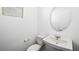 Simple powder room featuring a pedestal sink, toilet, and a round mirror with good lighting at 647 N Water St, Henderson, NV 89015
