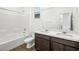 Bathroom features a tub shower and double sink vanity with dark cabinets at 647 N Water St, Henderson, NV 89015