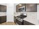 Close up of kitchen stove and stainless appliances, alongside updated white countertops and cabinetry at 647 N Water St, Henderson, NV 89015
