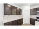Close-up of kitchen cabinets, white countertops, and marble-look backsplash, offering ample storage at 647 N Water St, Henderson, NV 89015