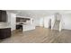 Bright living room with wood-look tile flooring, open layout, and stairs to the upper level at 647 N Water St, Henderson, NV 89015