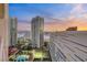 Panoramic view of city buildings including tennis courts, and pool under a colorful sky at 2747 Paradise Rd # 2206, Las Vegas, NV 89109