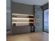A sleek wet bar featuring illuminated shelves, a wine cooler, and stylish cabinetry, with a stacked stone accent wall at 323 Wanda Rd, Henderson, NV 89002