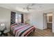 Striped bedding adorns a bedroom with wood-look floors and ensuite bath access at 537 Kristin Ln, Henderson, NV 89011