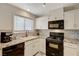 White kitchen with black appliances and granite counters at 537 Kristin Ln, Henderson, NV 89011