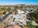 Sweeping aerial view of a contemporary home showcasing modern design, neutral color palette, and lush surrounding landscape at 2401 Driftwood Dr, Las Vegas, NV 89107