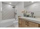 Modern bathroom featuring a tub and shower combo with patterned gray tile and a wood vanity at 2401 Driftwood Dr, Las Vegas, NV 89107