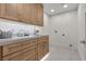 Bright laundry room with wood cabinets, sink, and tile floor at 2401 Driftwood Dr, Las Vegas, NV 89107