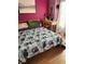 Bright bedroom featuring a cozy bed with patterned bedding, a wooden desk and hardwood floors, creating a warm atmosphere at 4764 Anchorage St, Las Vegas, NV 89147