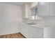 Bright kitchen with white cabinets, laminate flooring, and stainless steel sink at 120 Maple St, Henderson, NV 89015