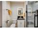 Bathroom with a tiled shower, stylish vanity with a dark countertop, a lighted mirror, and a toilet at 2240 Mohigan Way, Las Vegas, NV 89169