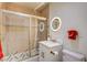 Bathroom with a tiled shower, stylish vanity with a white countertop, a circular lighted mirror, and a toilet at 2240 Mohigan Way, Las Vegas, NV 89169