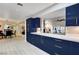 Open kitchen with modern blue cabinetry, sleek countertops, and a seamless transition to the dining area at 2240 Mohigan Way, Las Vegas, NV 89169