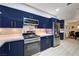 Contemporary kitchen with stainless steel appliances, blue cabinets, and a view into the dining area at 2240 Mohigan Way, Las Vegas, NV 89169