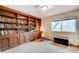 Library features a full wall of custom shelving, chair, and an ottoman next to a window at 2240 Mohigan Way, Las Vegas, NV 89169