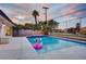 Backyard swimming pool with modern fire feature and view of surrounding foliage and golf course at 2240 Mohigan Way, Las Vegas, NV 89169