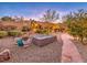 Landscaped backyard with stone pathway, fire pit, and mature trees at 3 Palmbrook Ln, Henderson, NV 89052