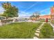 Landscaped backyard with stone pathway and lush lawn at 3 Palmbrook Ln, Henderson, NV 89052