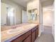 Double vanity bathroom with light beige tile and wood cabinets at 3 Palmbrook Ln, Henderson, NV 89052